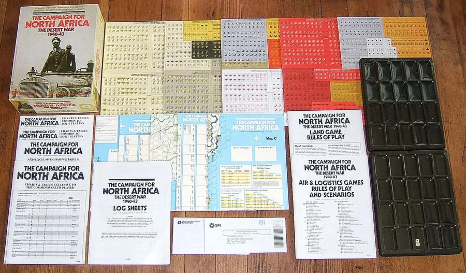 Các thành phần của board game The Campaign For North Africa, bao gồm nhiều sách luật, bàn cờ và tờ quân cờ.